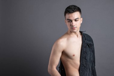 Stüdyoda poz veren seksi genç adam. Gri arkaplan