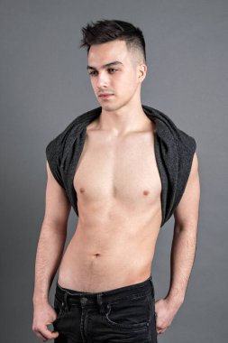 Stüdyoda poz veren ciddi bir genç.