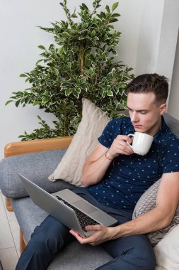 mutlu genç adam kanepede oturan