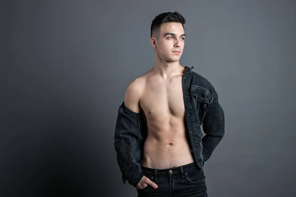 Sexy young man posing in studio. Gray background — Stock Photo, Image