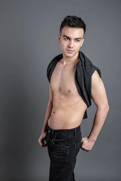 Sexy young man posing in studio. Gray background — Stock Photo, Image