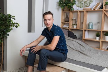 Merdivenlerde oturan genç yakışıklı adam