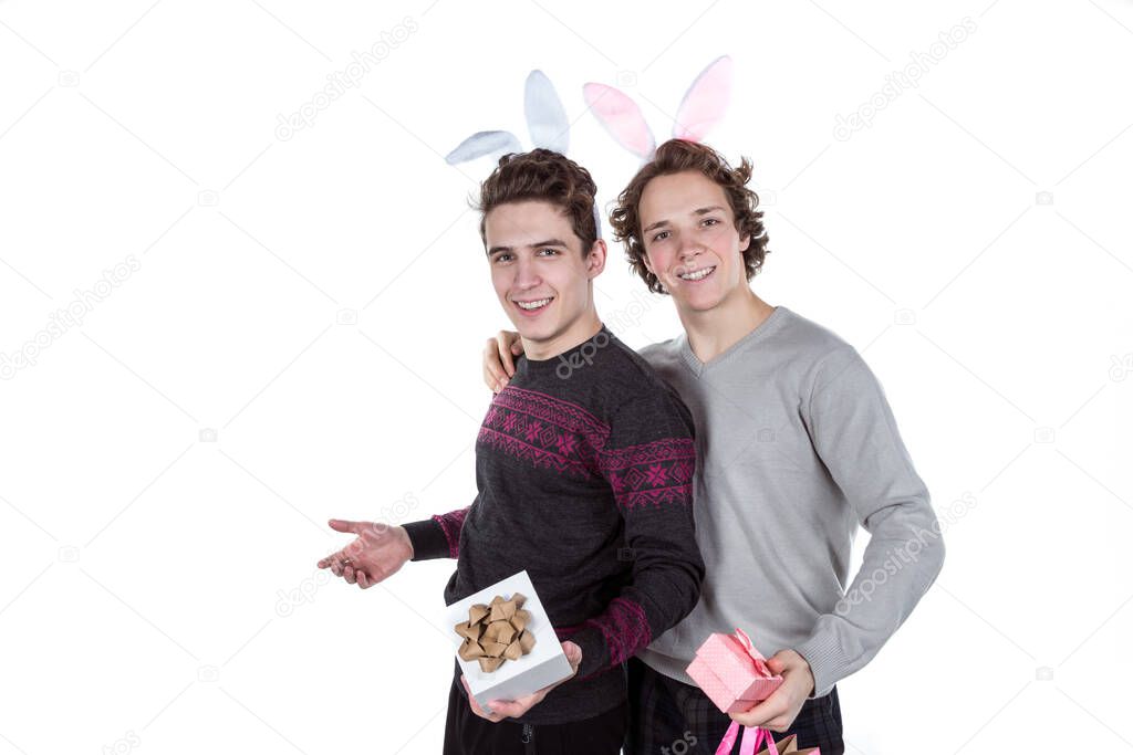 Two happy young men in a rabbit-like ears holding up gift boxes