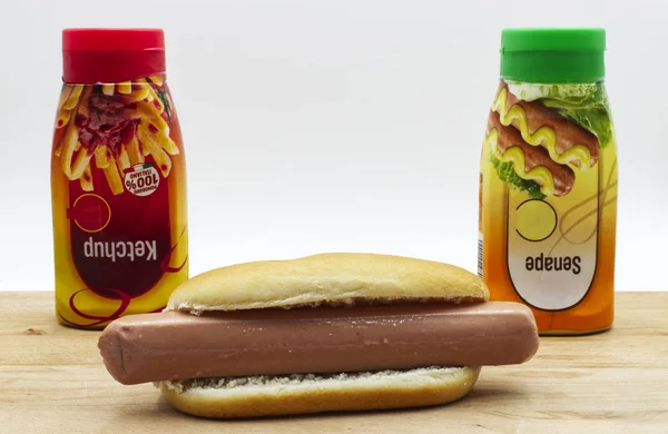 Frisse Hotdog Met Ketchup Mosterd Dispenser Houten Tafel Witte Achtergrond — Stockfoto
