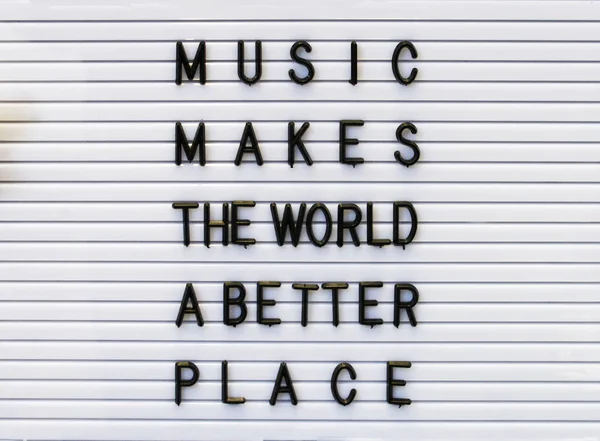 Music makes the world a better place concept made by plastic letters on a white board.