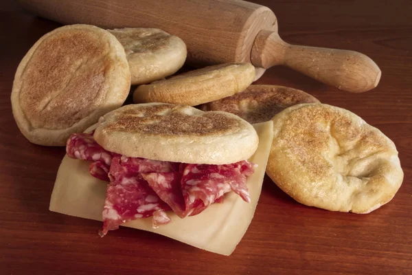 Tahta masadaki Tigelle. Emilia-Romagna bölgesinden geleneksel İtalyan yemekleri.