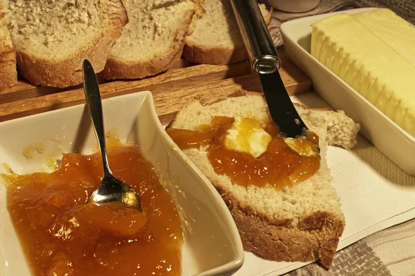 Slices of bread, butter and peach jam for breakfast