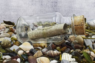 Plajda içinde taş ve mermi olan bir şişede mesaj. Stüdyo çekimi