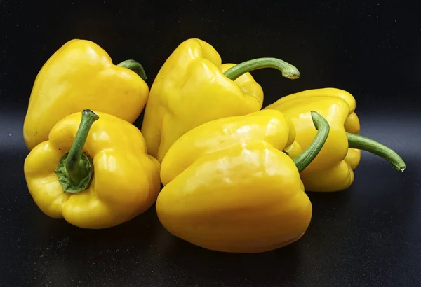 Fresh yellow peppers isolated on black background