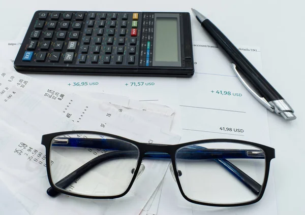 Checking receipt and account balance. Calculator, glasses and pen isolated on white