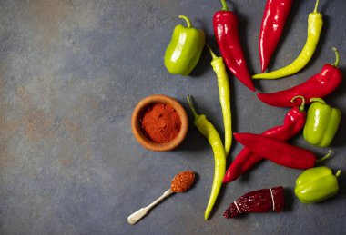 Biberler. Farklı biber çeşitleri. Kırmızı biber, yeşil biber, acı biber, kurutulmuş kırmızı biber, kırmızı biber tozu, biber, baharat. Üst Manzara. Karanlık arka plan. Metin için boşluk