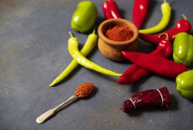 Biberler. Farklı biber çeşitleri. Kırmızı biber, yeşil biber, acı biber, kurutulmuş kırmızı biber, kırmızı biber tozu, biber, baharat. Üst Manzara. Karanlık arka plan. Metin için boşluk