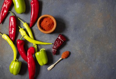 Biberler. Farklı biber çeşitleri. Kırmızı biber, yeşil biber, acı biber, kurutulmuş kırmızı biber, kırmızı biber tozu, biber, baharat. Üst Manzara. Karanlık arka plan. Metin için boşluk