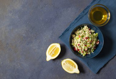 Kuskus, maydanoz, limon, domates ve zeytinyağlı Tabbouleh salatası. Levantine vejetaryen salatası. Lübnanlı, Arap mutfağı. Karanlık arka plan. Üst Manzara. Metin için boşluk
