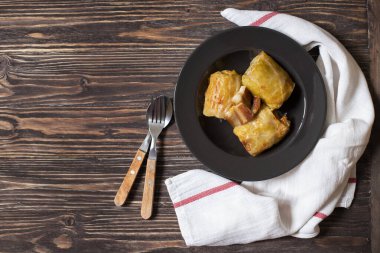 Sarma - geleneksel Balkan mutfağı. Et ve pirinçle lahana rulosu. Balkan mutfağı. Sırp mutfağı. Koyu ahşap arka plan. Üst Manzara. Metin için boşluk