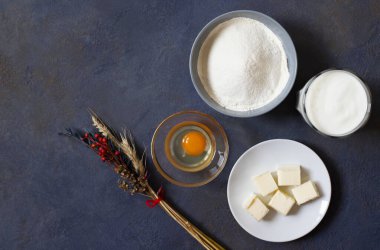 Koyu arkaplanda krep ve krep malzemeleri. Un, yumurta, süt, tereyağı, çırpı. Üst Manzara. Metin için boşluk.