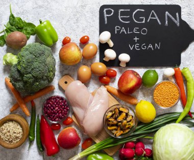 Pegan diyeti. Vegan ve paleo diyetlerinin birleşimi. Sağlıklı yiyecek - taze sebze ve meyve çeşitleri, tavuk, yumurta, midye, baklagil, mantar.