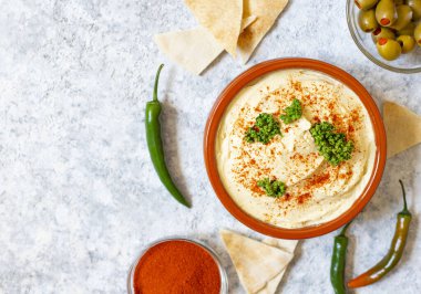 Paprika tozu, pita ekmeği, zeytin ve maydanozla servis edilen sağlıklı ev yapımı humus. Orta Doğu mutfağı, İsrail mutfağı, Levan mutfağı, Levantine mutfağı.