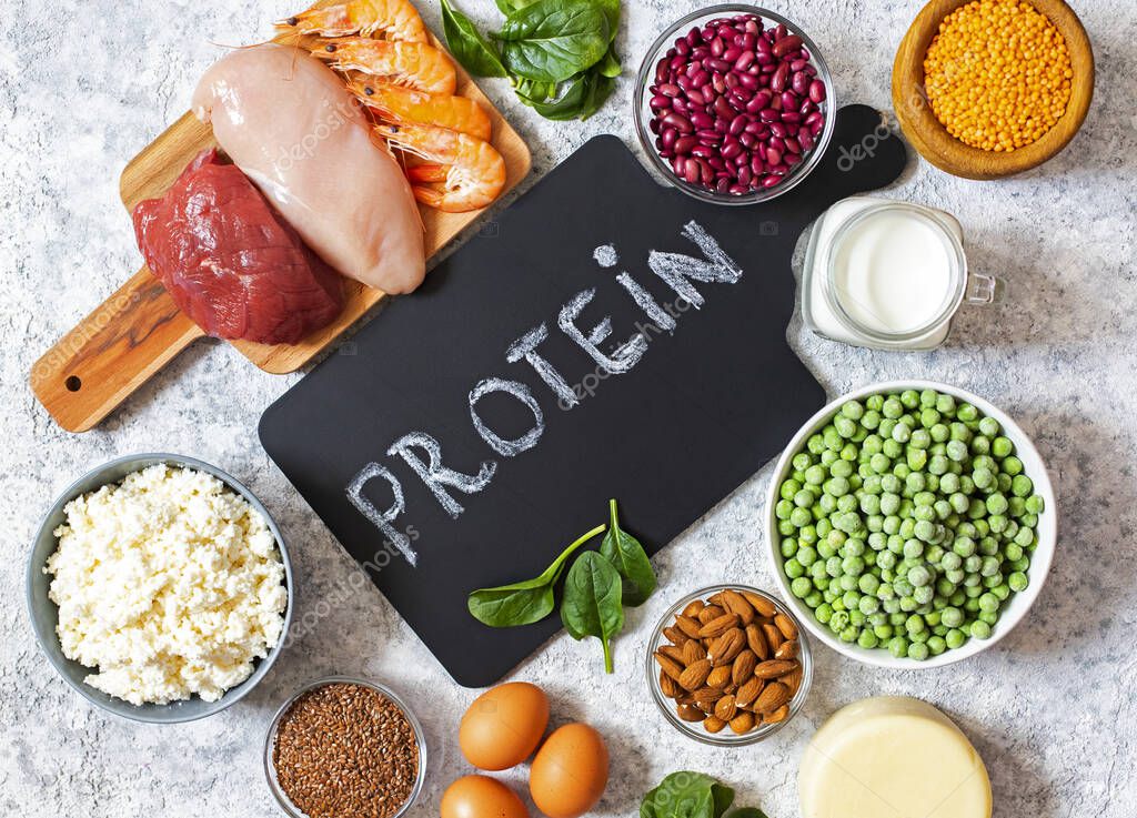 Assortment of Products with high level of protein. Healthy Protein Source. Foods for muscles building. Meat, seafood, cheese, milk, nuts, legumes, seeds, eggs, vegetables. Light background. Top view