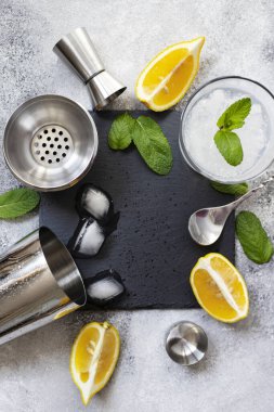 Kokteyl karıştırıcı ve bar aletleri. Soğuk bir alkollü kokteyl için gerekli malzemeler. Mojito kokteyli. Limon, nane, buz, rom. Üst görünüm