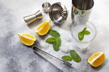 Kokteyl karıştırıcı ve bar aletleri. Soğuk bir alkollü kokteyl için gerekli malzemeler. Mojito kokteyli. Limon, nane, buz, rom. Üst görünüm