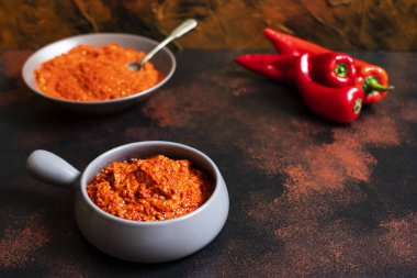 Koyu arkaplanda bir tabakta kırmızı biber tozu. Seçici odaklanma. Yakın plan.