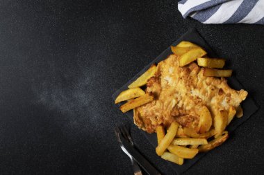 Tabağında patates kızartması olan geleneksel İngiliz balığı. Mesaj için yer var. Yakın çekim görünümü
