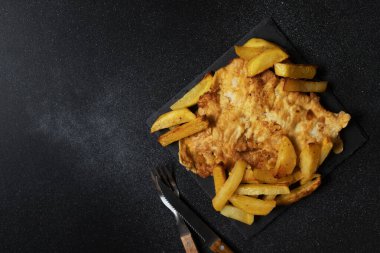 Tabağında patates kızartması olan geleneksel İngiliz balığı. Mesaj için yer var. Yakın çekim görünümü