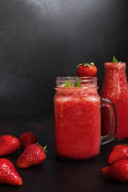 Kavanozda buzlu çilekli meyve püresi ve çilek. Ferahlatıcı bir yaz içkisi. Yakın çekim görüntüsü. Boşluğu kopyala