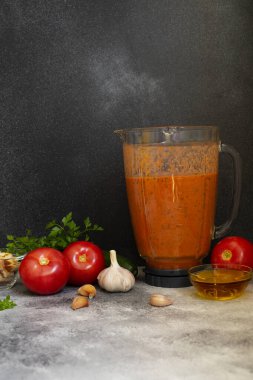 Geleneksel soğuk domates çorbası karışımında gazpacho malzemesi. Domates, biber, sarımsak, fesleğen, maydanoz, zeytinyağı ve kızarmış ekmek. Akdeniz, İspanyol mutfağı. Siyah arka plan. Boşluğu kopyala
