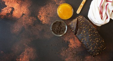 Koyu ahşap arka planda tam tahıllı çavdar ekmeği, bal ve malt. Taze pişmiş ev yapımı ekmek. Üst Manzara. Koyu kırsal bir geçmişi var. Boşluğu kopyala