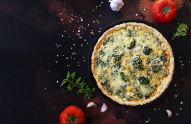 Peynirli, brokolili, ıspanaklı ve tavuklu geleneksel Fransız kiş. Kiş lorraine. Fransız mutfağı. Üst Manzara. Koyu kırsal arkaplan