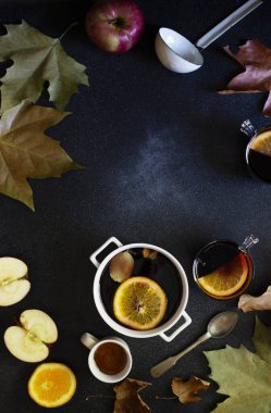 Beyaz kupa ve sıcak şarap. Sonbahar ve kış ılık alkolik içeceği. Sonbahar yaprakları, bal, elma, portakal, klasik yemekler. Sonbahar sıcacık havası. Düz, koyu arkaplan