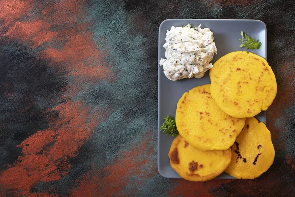 Latin American breakfast Arepas of ground maize dough with cheese and herbs. Cuisine of Venezuela and Colombia. Top view, bright background, copy space