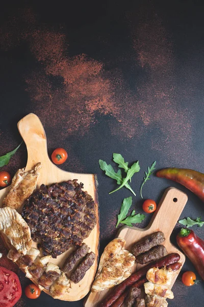 Különböző Grillezett Húsokat Szolgáltak Fel Vágódeszkákon Friss Zöldségekkel Kenyérrel Sötét — Stock Fotó