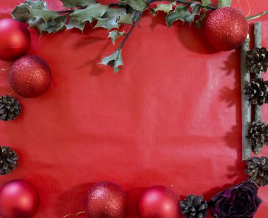 Kırmızı arkaplan hediye kartı görünümünde çeşitli Noel dekoratif nesneleri içeren bir çerçeve kompozisyonu