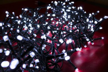 Kırmızı arka plandaki noel ışıklarının yakın plan görüntüsü hediye kartı, noel süslemeleri ve tatiller