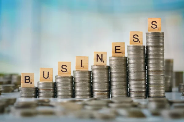 Stack of Coins with Wooden Scrabble Letters — Stock Photo, Image