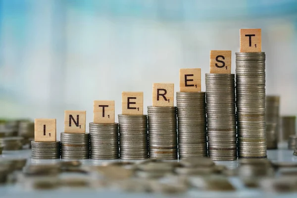 Stack of Coins with Wooden Scrabble Letters — Stock Photo, Image