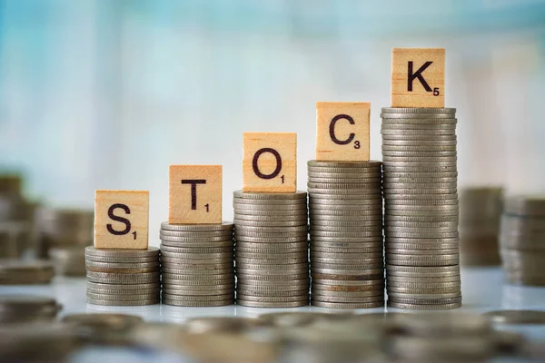 Stack of Coins with Wooden Scrabble Letters — Stock Photo, Image