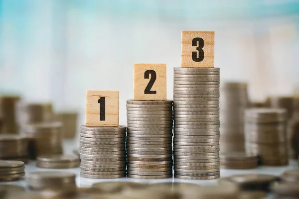 Stack of Coins with Wooden Scrabble Letters — Stock Photo, Image