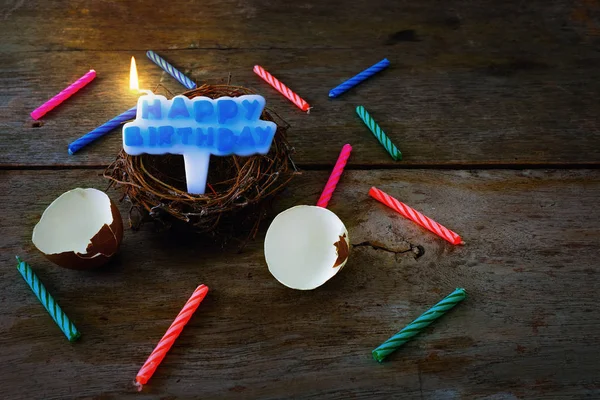 Casca de ovo quebrada com ninho e vela para o Feliz Aniversário Conce — Fotografia de Stock