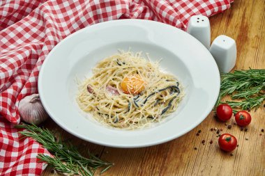 Pastırmalı ev yapımı makarna, yumurta sarısı ve ahşap arka planda parmesan peyniri. Yaklaş, seçici odaklanma