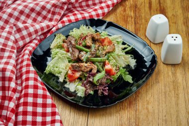 İştah açıcı salata, sığır eti ve ahşap arka planda taze sebzeler. Sağlıklı beslenme. Kapat, boşluğu kopyala