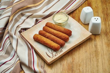 Ahşap arka planda reçelli beyaz tabakta kızarmış mozzarella peyniri çubukları. Lezzetli bira..