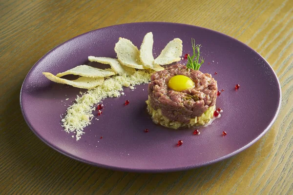 Fresh beef tartar with capers, sawn egg yolk and parmesan cheese. Delicious appetizer. Close up view