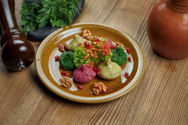 Seramik tabakta Pkhali. Uzayı kopyala Geleneksel Gürcü aperatifi Pkhali doğranmış ve doğranmış lahana, patlıcan, ıspanak, fasulye, pancar ve ceviz, sarımsak ve bitkilerle birleştirilmiştir.