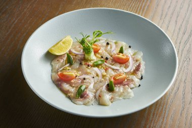 Yakın plan deniz levreği ceviche beyaz kase ahşap arka planda servis edilir. Taze ve lezzetli cebiche. Çiğ balık. Latin Amerika mutfağı. Kazıkta tahıl sesi