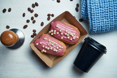 Beyaz arka planda pembe kremalı ve çilekli iki klasik eklem. Lezzetli kahve tatlısı. Üst manzara, düz konum yiyecek