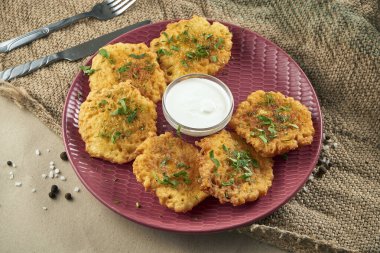 Geleneksel Ukrayna mutfağının yakın görüntüsü - Burgonya seramik tabağında ekşi kremalı patates gözlemesi